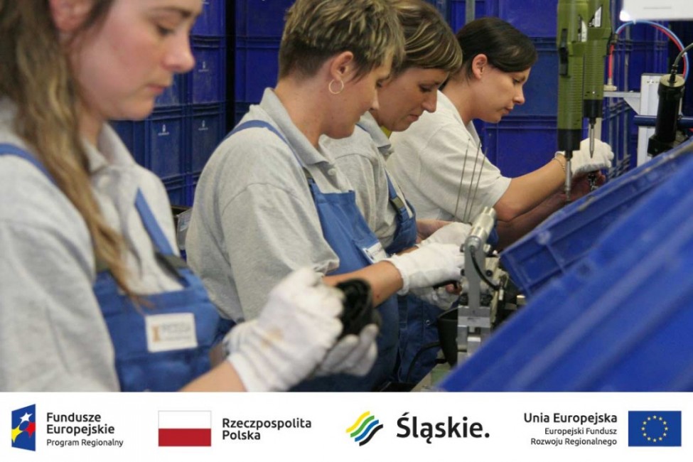 zdjęcie przedstawia kobiety pracujące na taśmie produkcyjnej, a pod nim umieszczono logotypy: Fundusze Europejskie - Program Regionalnym, Rzeczpospolita Polska, Śląskie, Unia Europejska - Europejski Fundusz Rozwoju Regionalnego 
